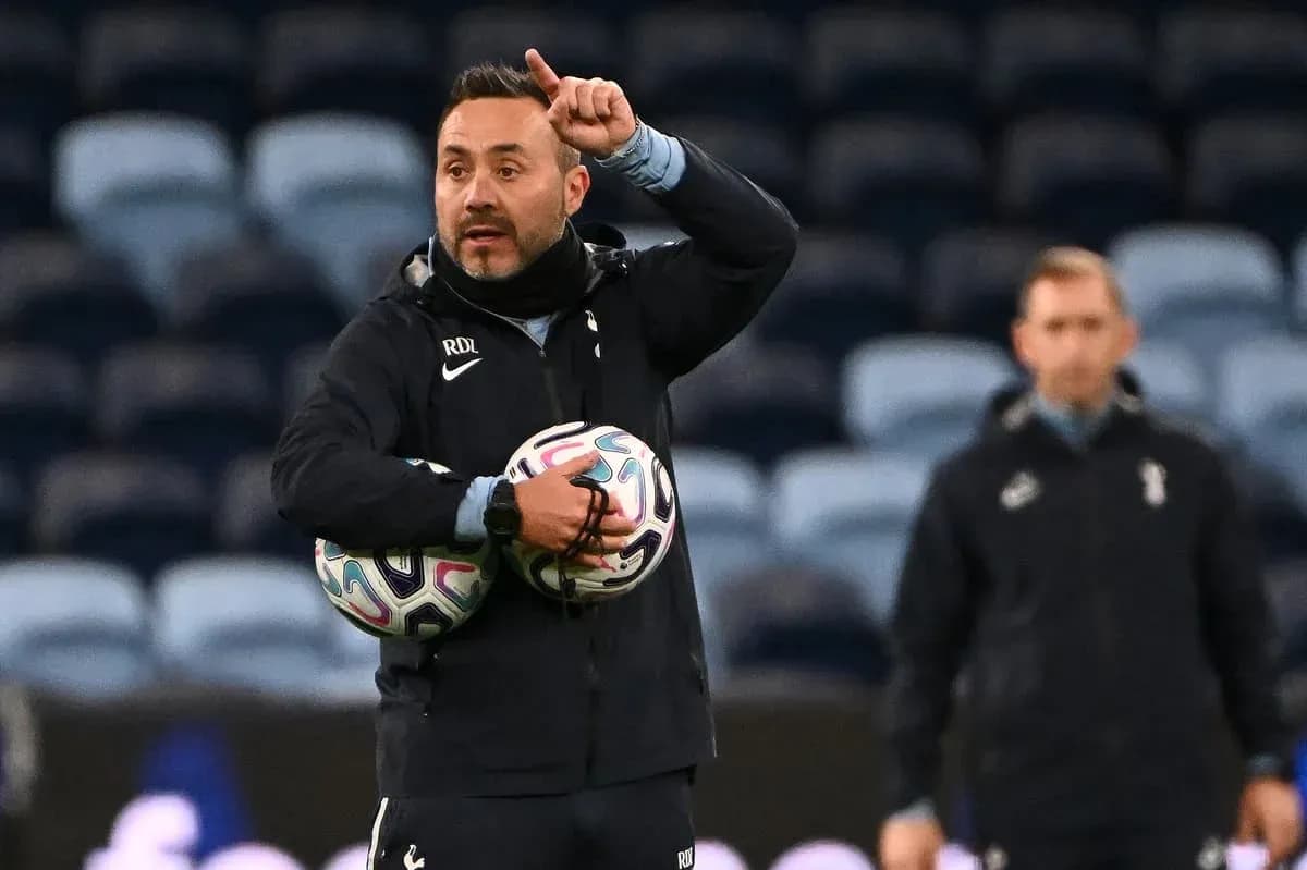 Coach instructing players while holding footballs