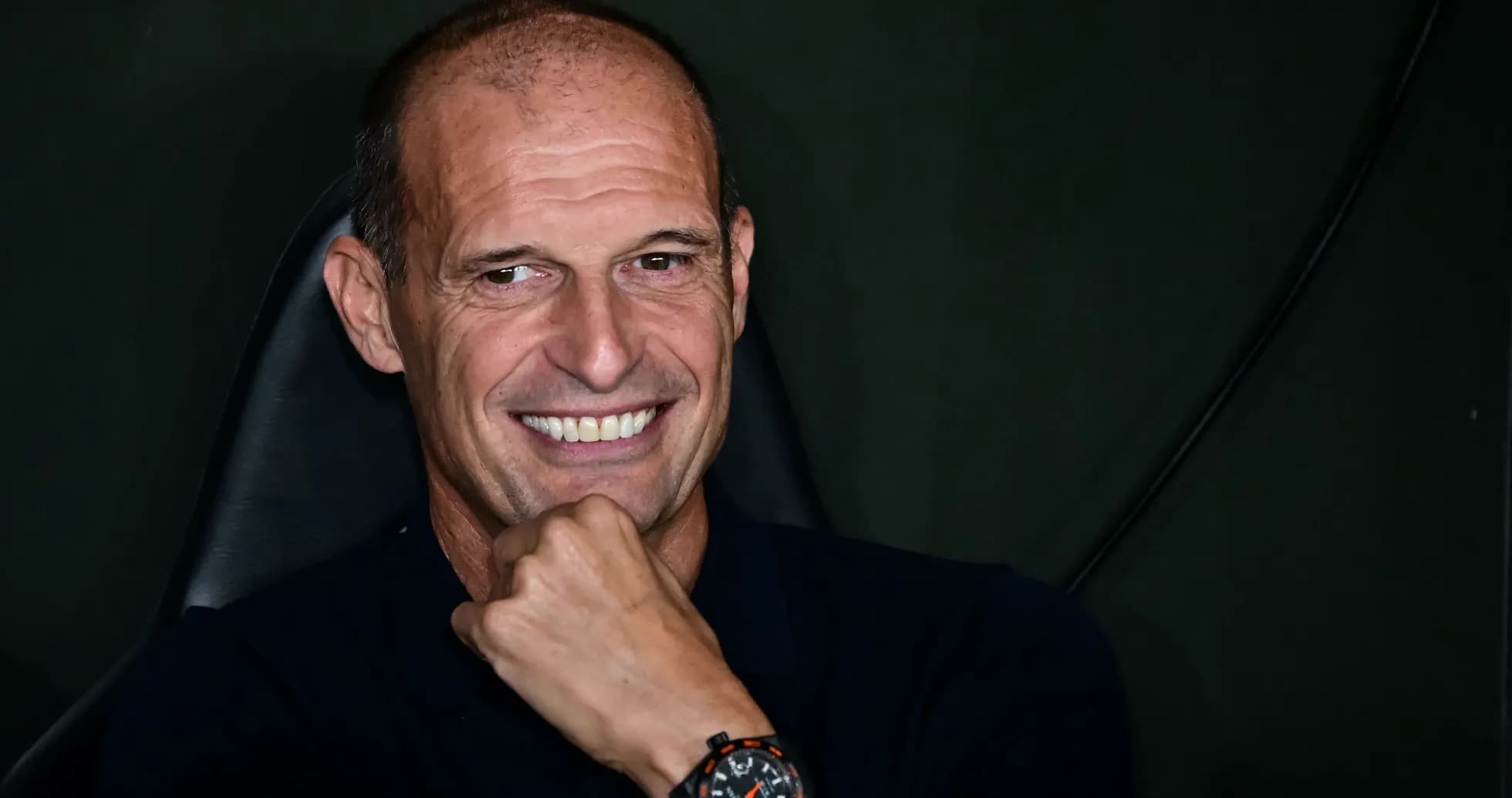 Coach smiling while sitting in chair