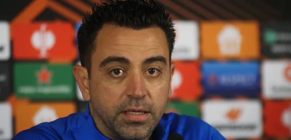 Manager speaking at press conference with logos behind