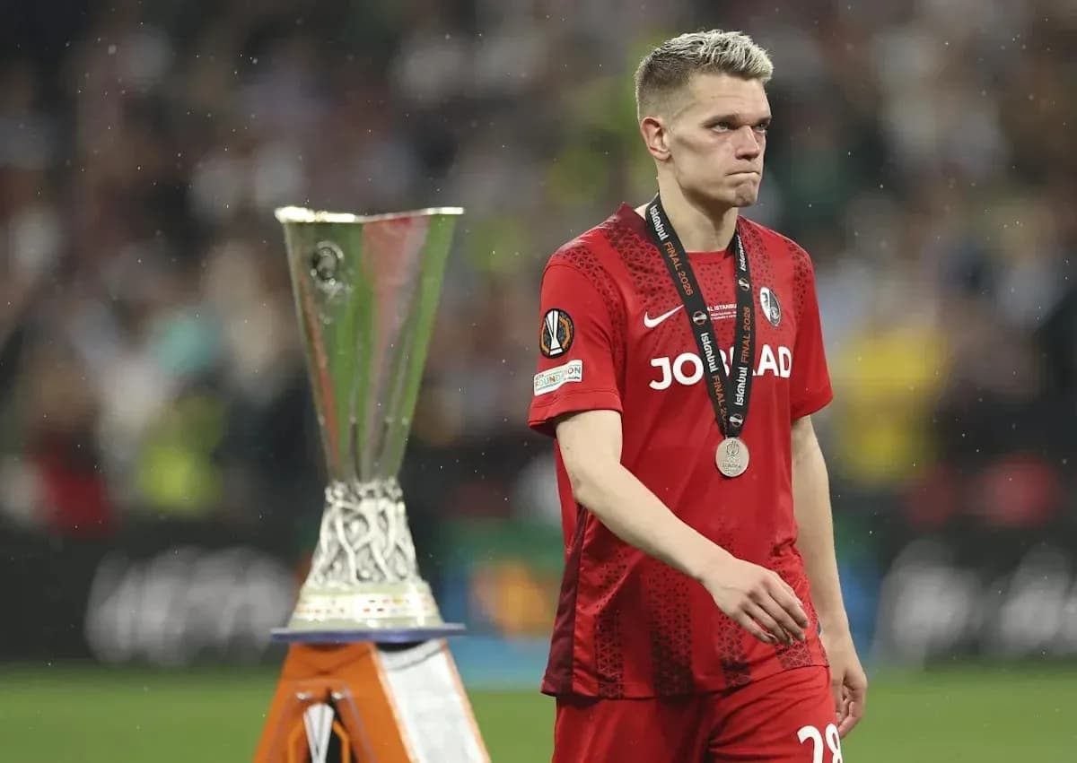 Player walking past UEFA Europa League trophy