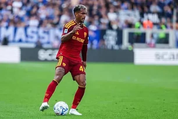 Player in red kit dribbling the ball on field