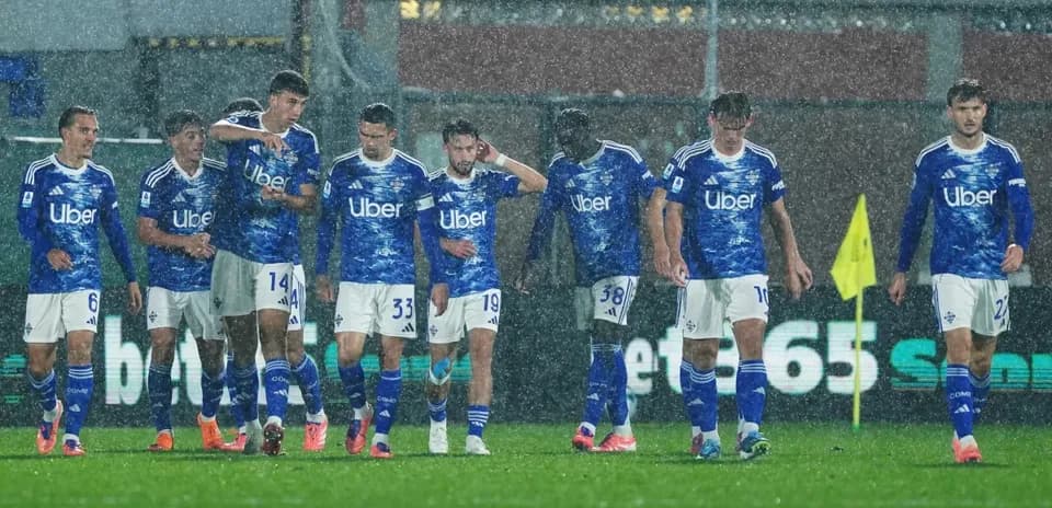 Como players walking in heavy rain during match
