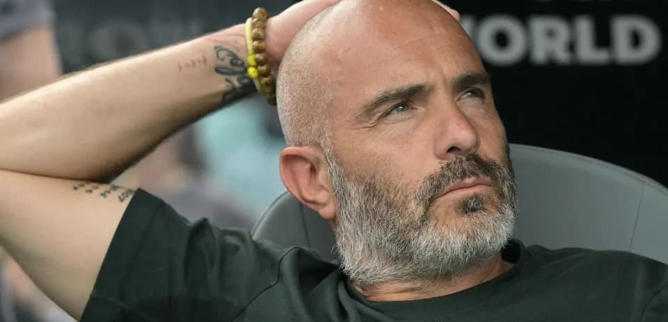 Coach sitting on bench during match contemplation