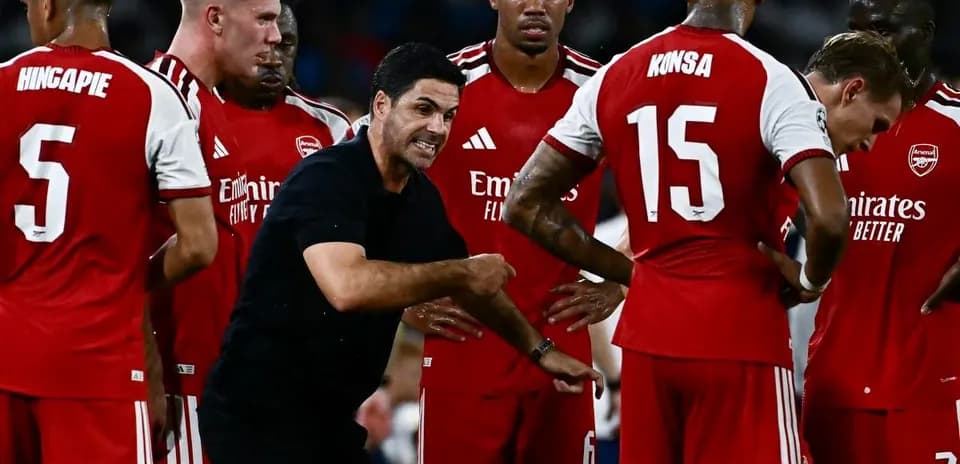 Manager discussing strategy with Arsenal players during match
