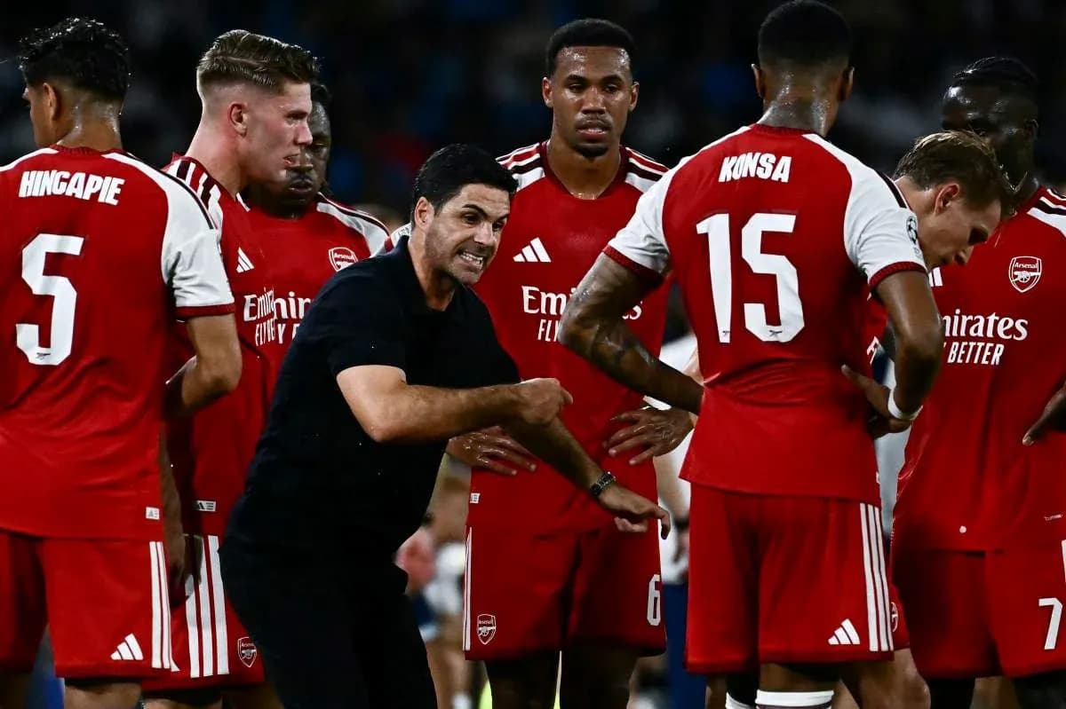 Manager discussing strategy with Arsenal players during match