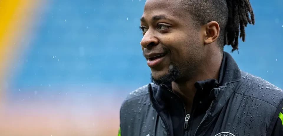 Player in Celtic Football Club jacket during rain
