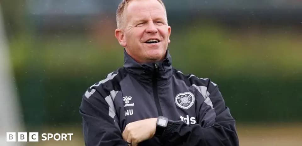 Coach standing with arms crossed during training session