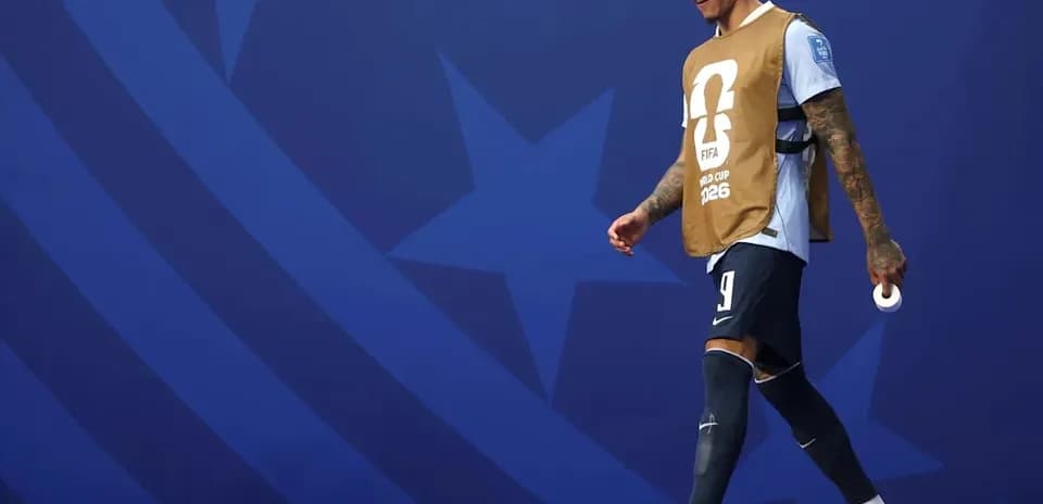 Player walking on the pitch wearing training bib