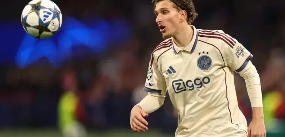 Player in Ajax kit reacting to airborne ball