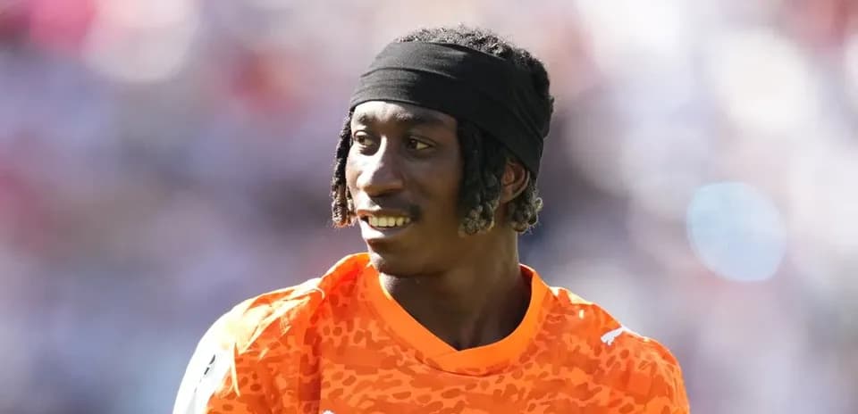 Goalkeeper wearing orange jersey during warm-up