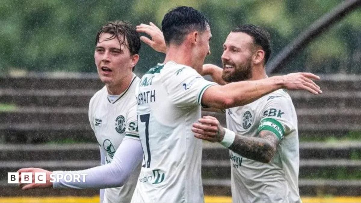 Hibernian players celebrating a goal in the rain