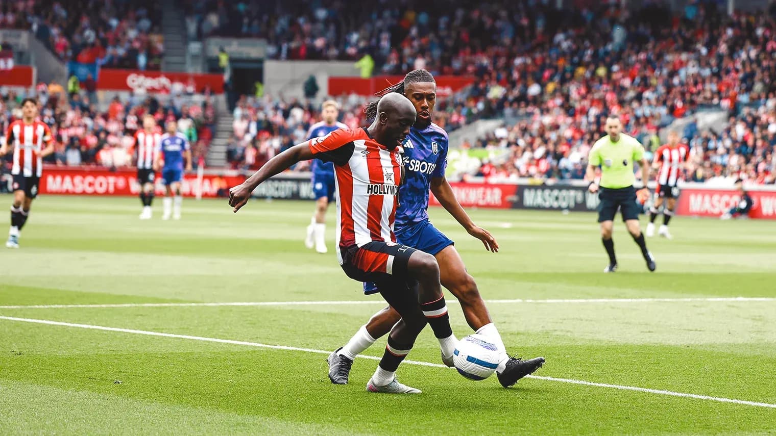 Brentford player tackling Fulham opponent