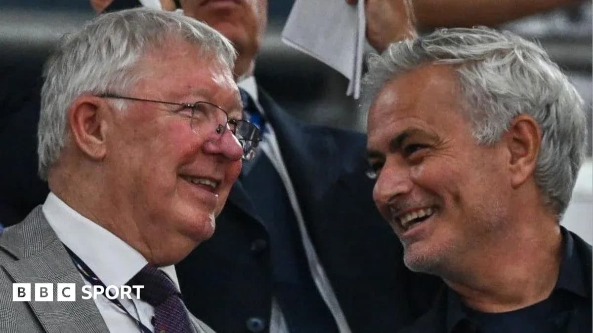 Two coaches smiling and talking in the stands