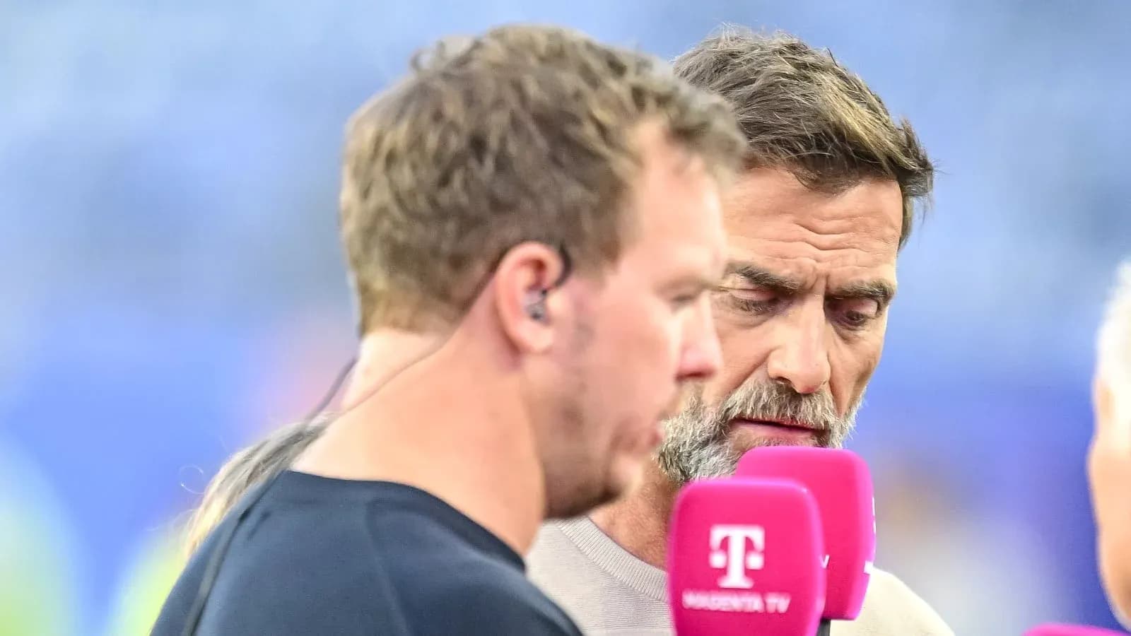 Two men discussing into microphones during broadcast
