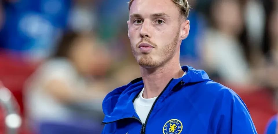 Player in Chelsea jacket on sidelines during match