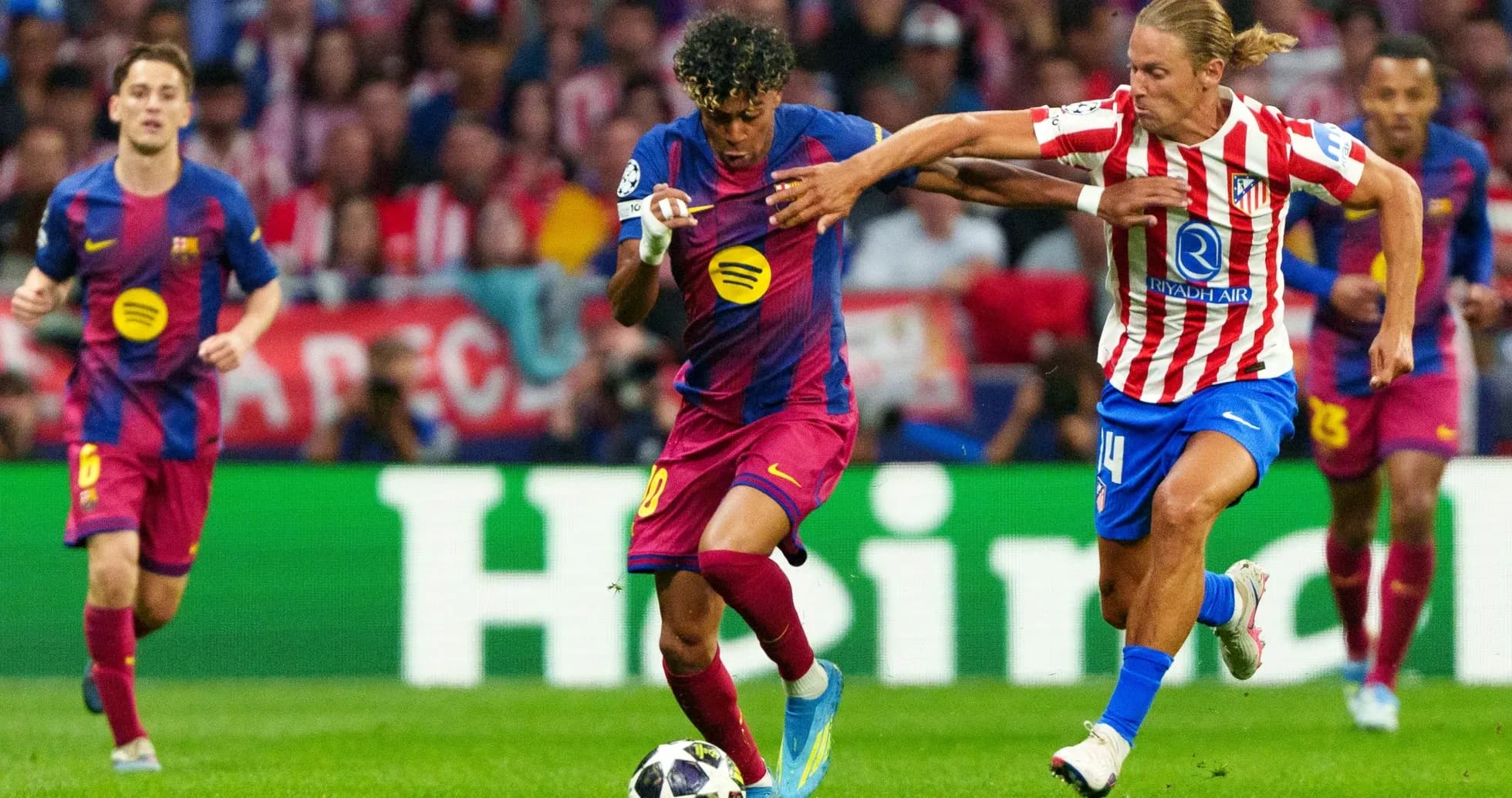 Atletico Madrid player challenging Barcelona forward