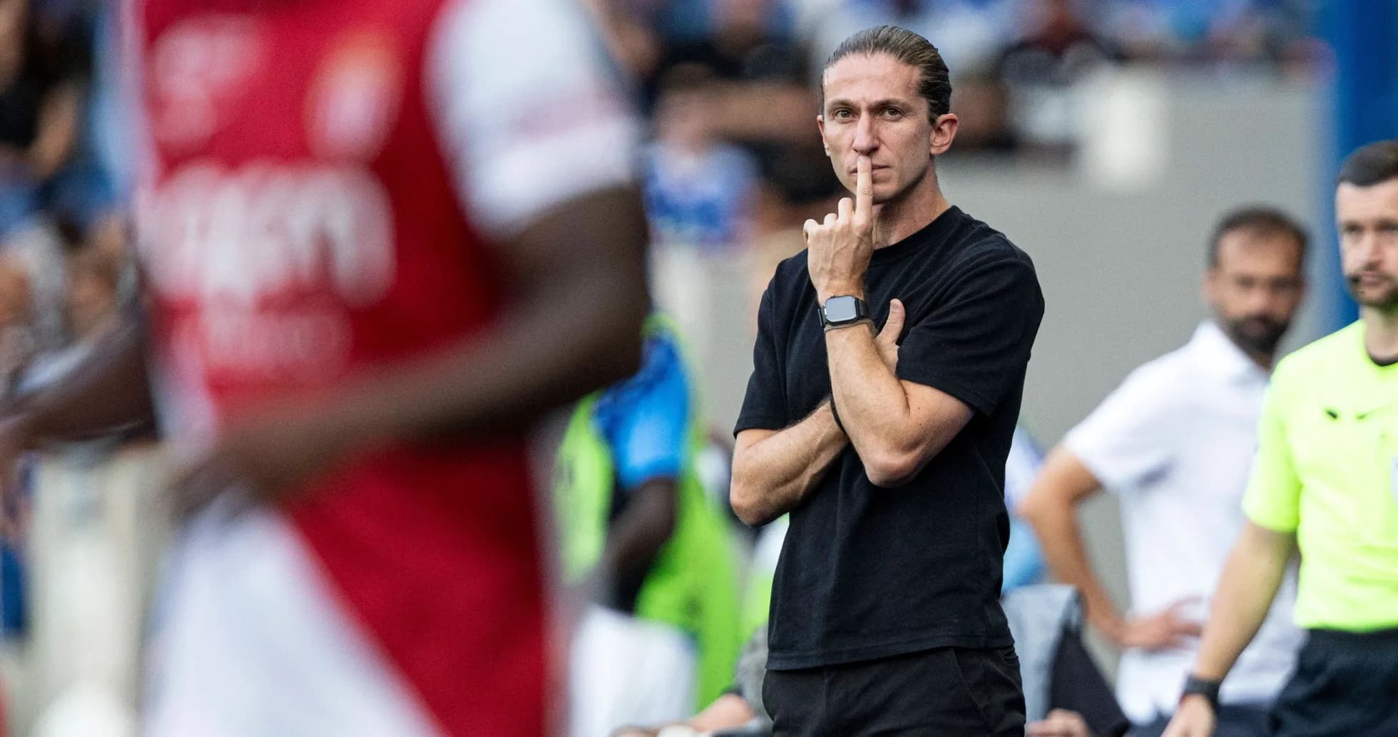 Coach observing the match with a finger to lips