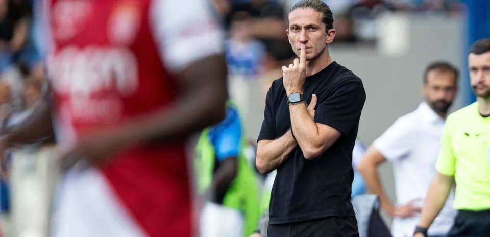 Coach observing the match with a finger to lips
