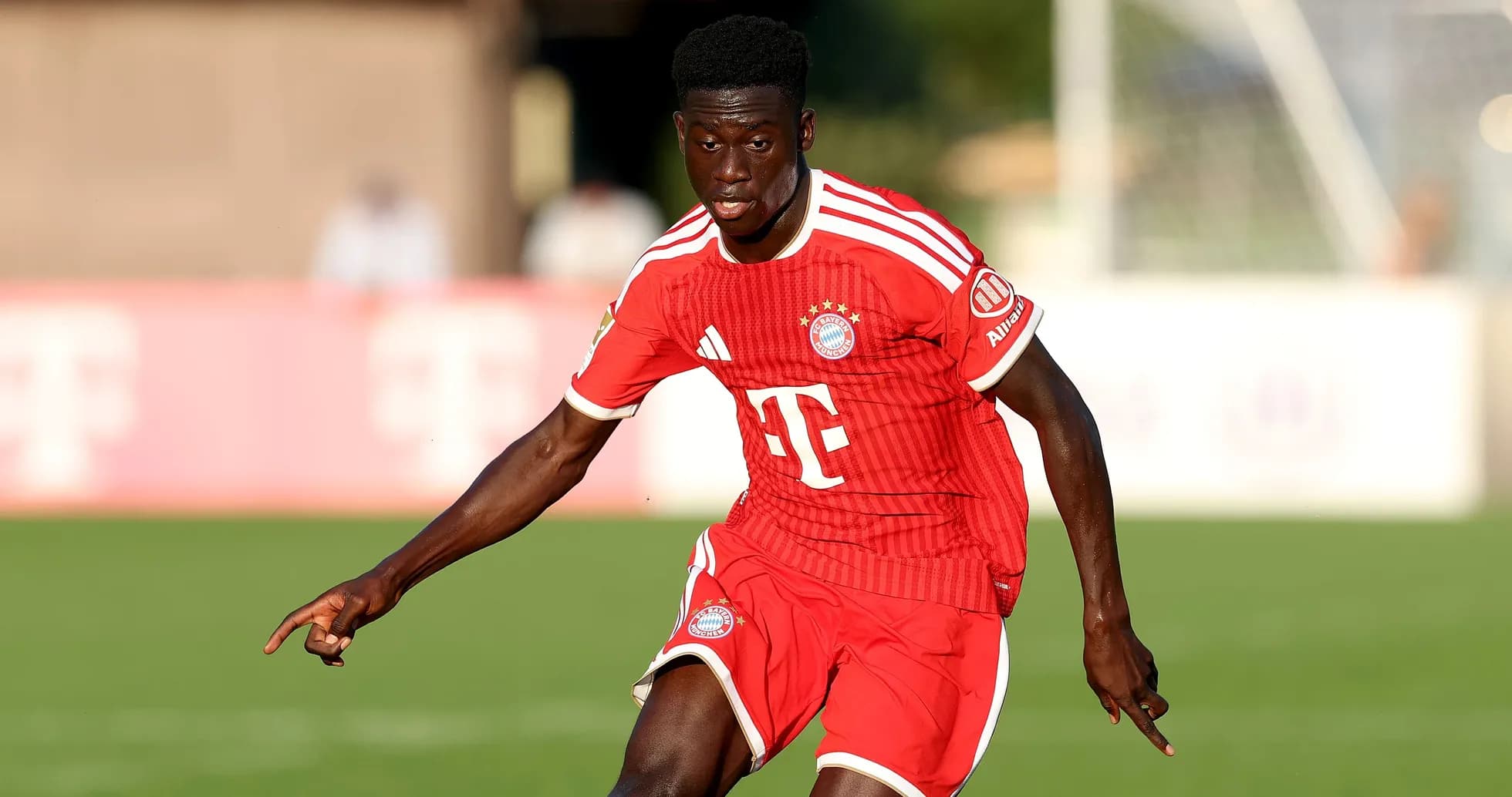 Player dribbling on the field in Bayern Munich kit
