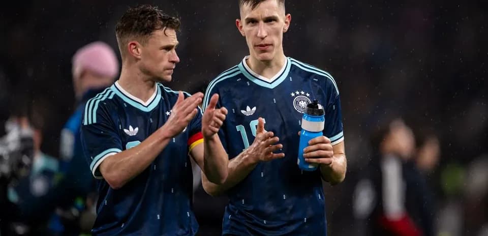 Two German players walking off the pitch post-match