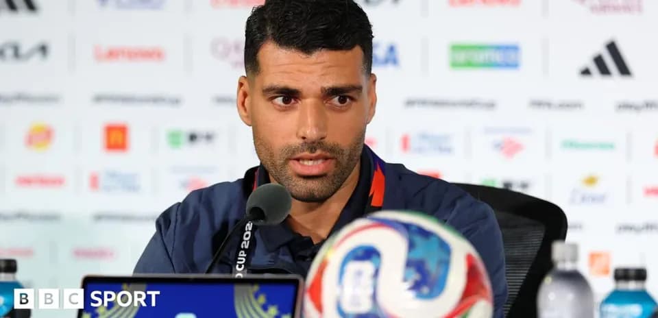 Player speaking at press conference with football