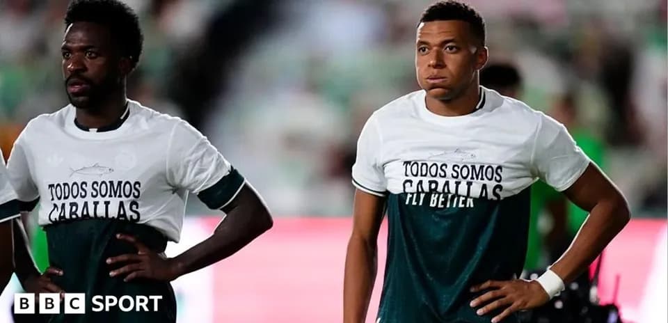 Two players wearing matching training shirts on pitch