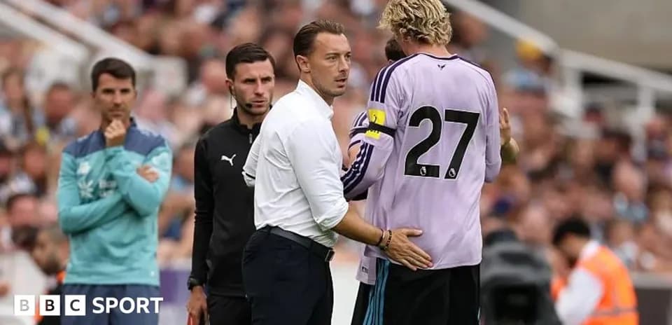 Coach discussing strategy with goalkeeper during match
