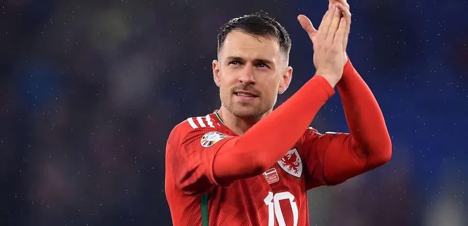 Player applauding fans after match in red jersey