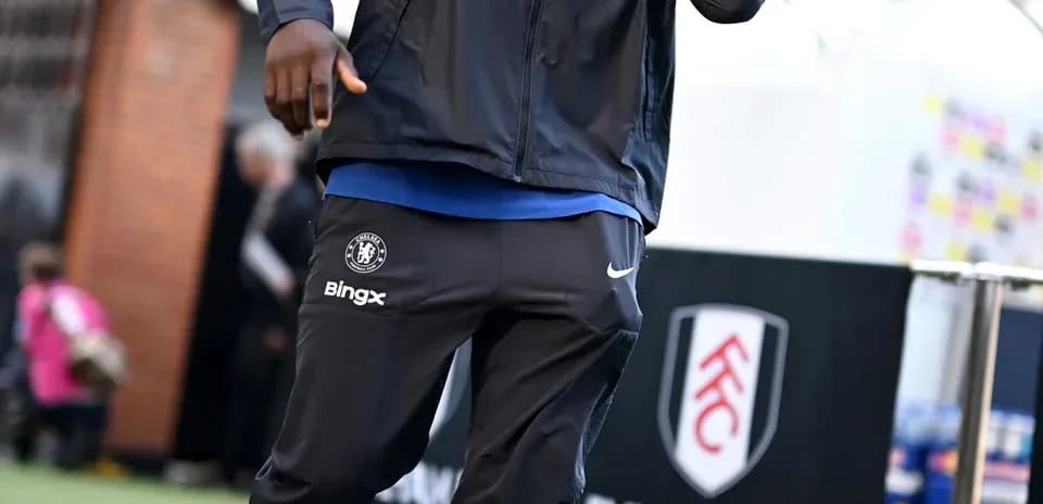 Player arriving at stadium in team tracksuit