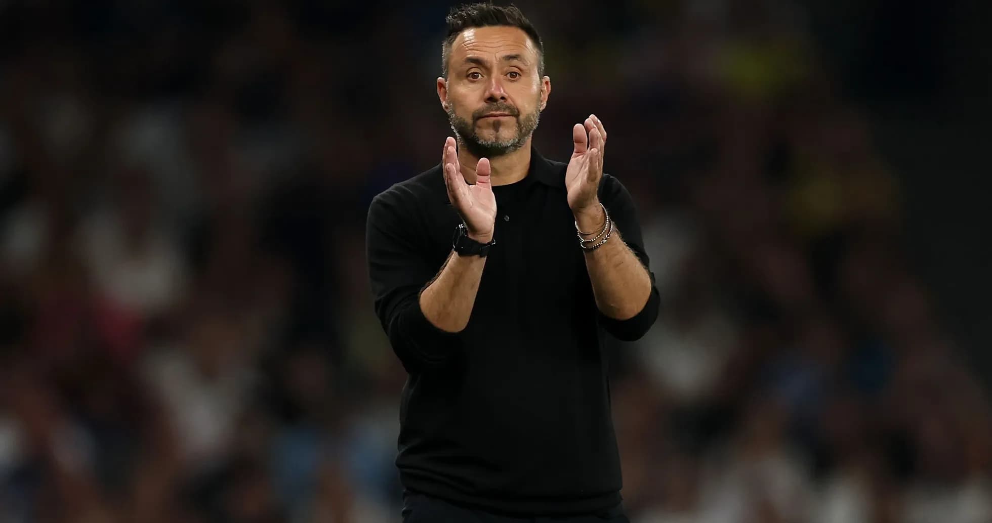 Coach applauding during a match on the sidelines