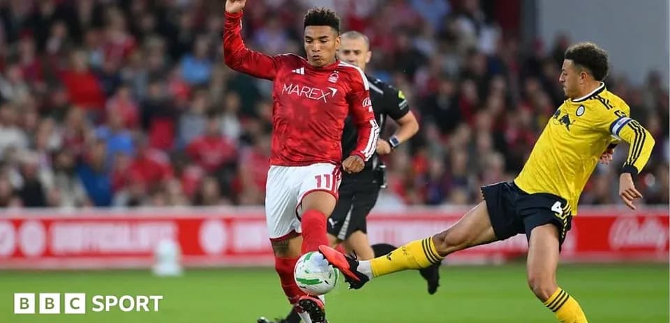 Player in red shirt evading tackle from opponent