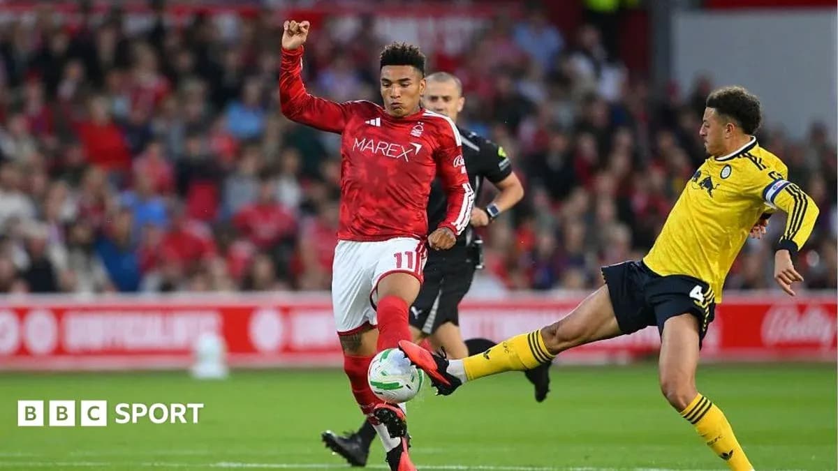 Player in red shirt evading tackle from opponent