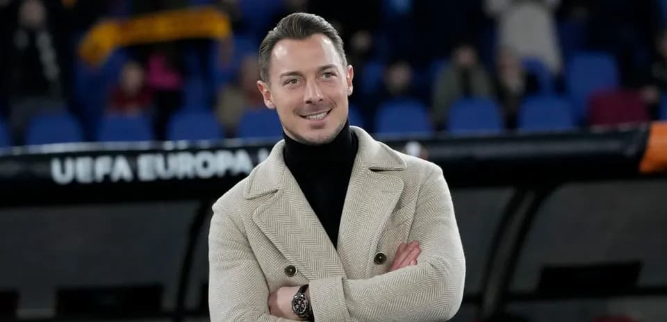 Man in stylish coat smiling on sidelines
