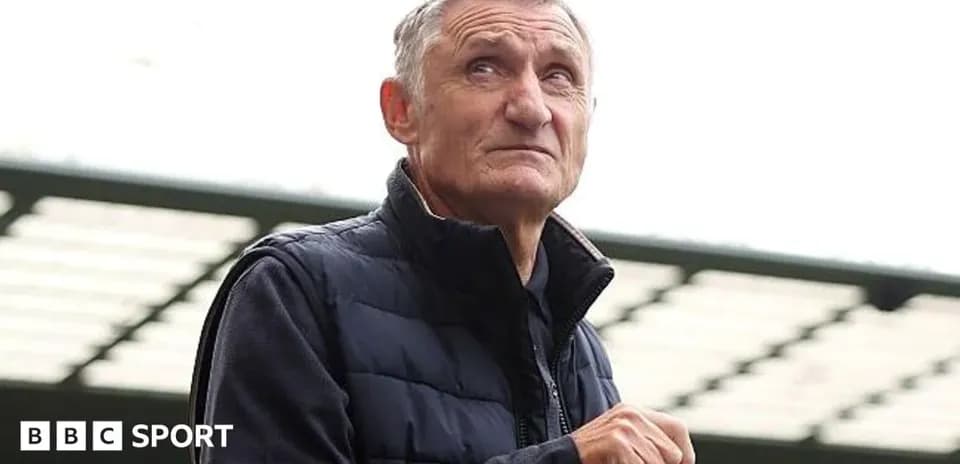 Man holding a drink at a sports venue