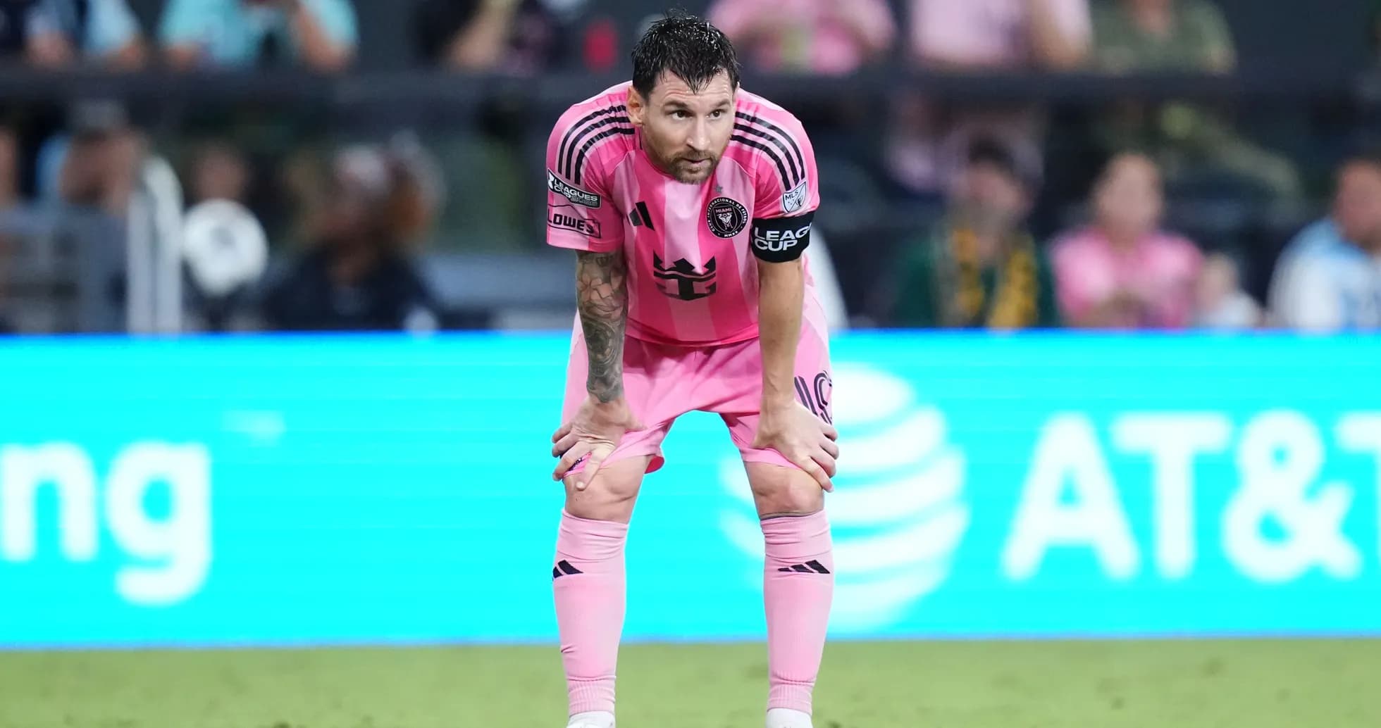 Player in pink kit leaning forward during match