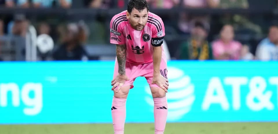 Player in pink kit leaning forward during match