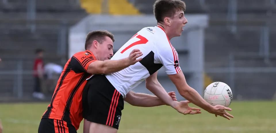 Player in red jersey tackling opponent for the ball