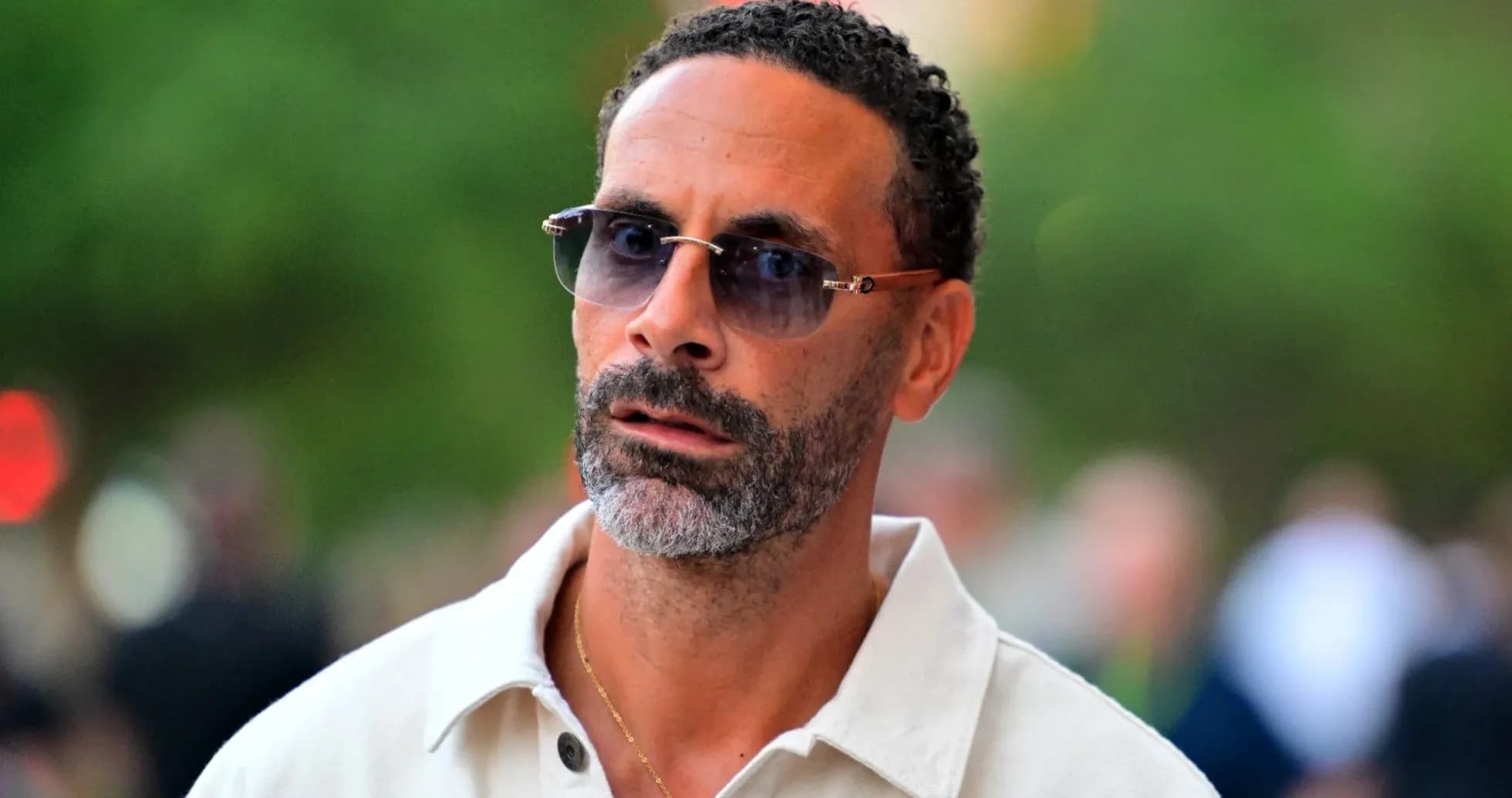 Man wearing sunglasses and a white shirt outdoors