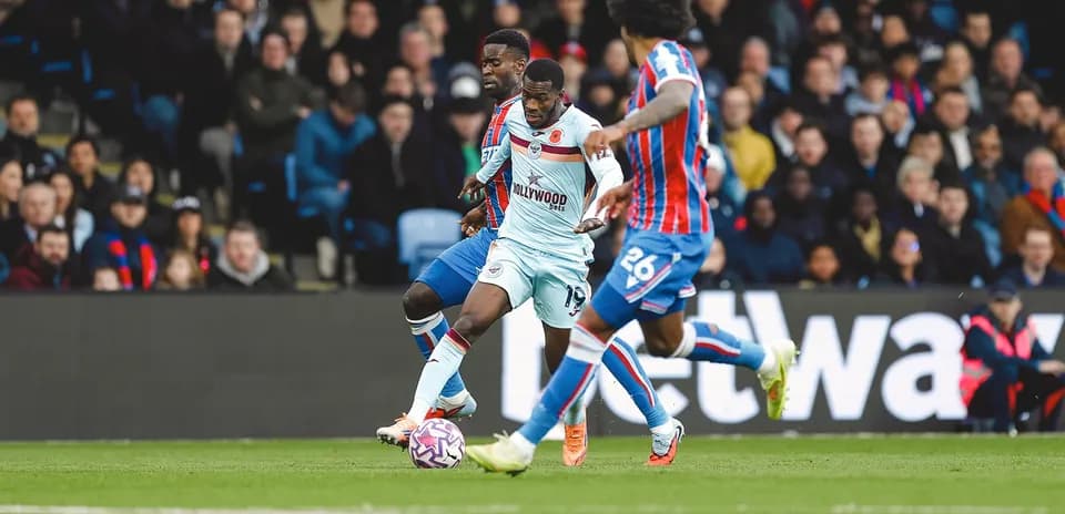Brentford player challenging Crystal Palace opponents