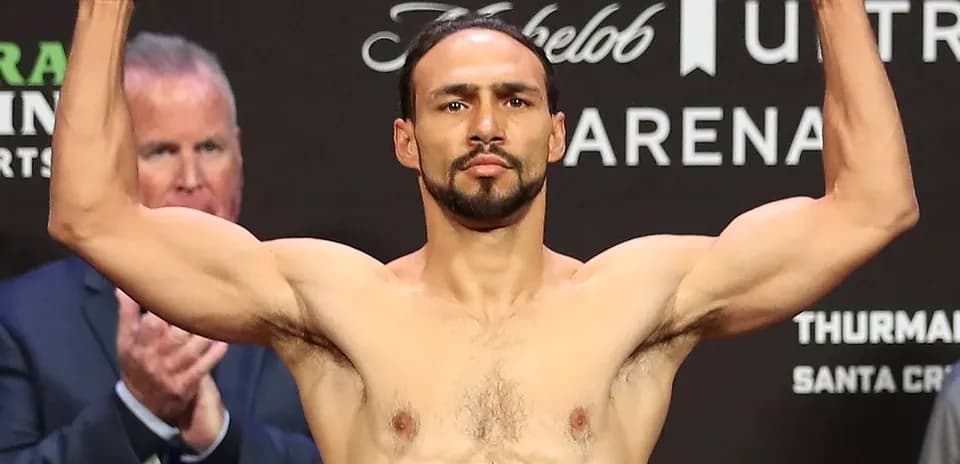Fighter weighing in with arms raised at event