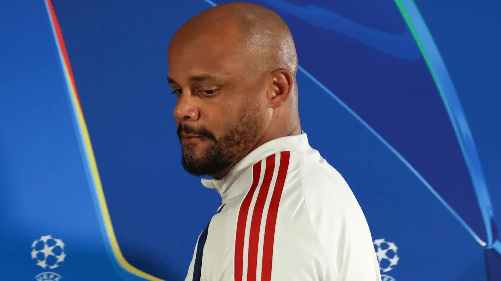 Manager walking past UEFA Champions League backdrop