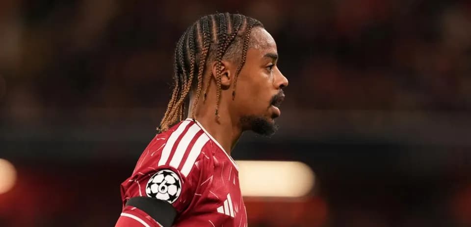 Player in red jersey during match with Champions League logo