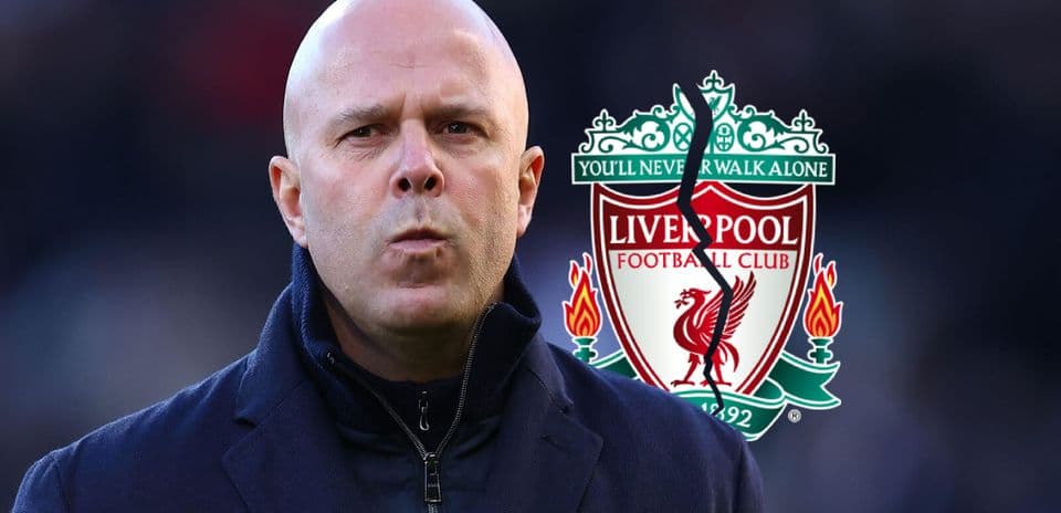 Man in suit with Liverpool FC logo in background