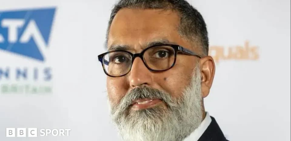 Man with glasses and beard at event backdrop