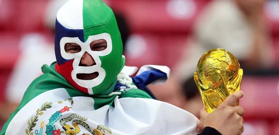 Fan wearing mask holding FIFA World Cup trophy