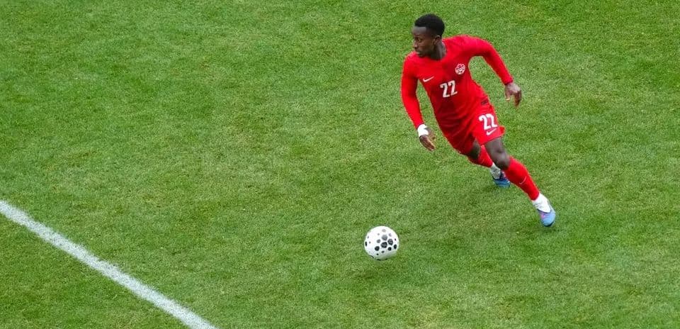 Player in red jersey running with ball