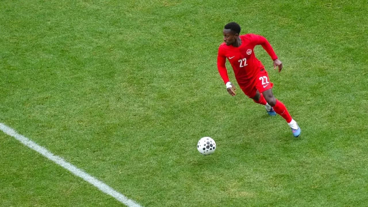 Player in red jersey running with ball