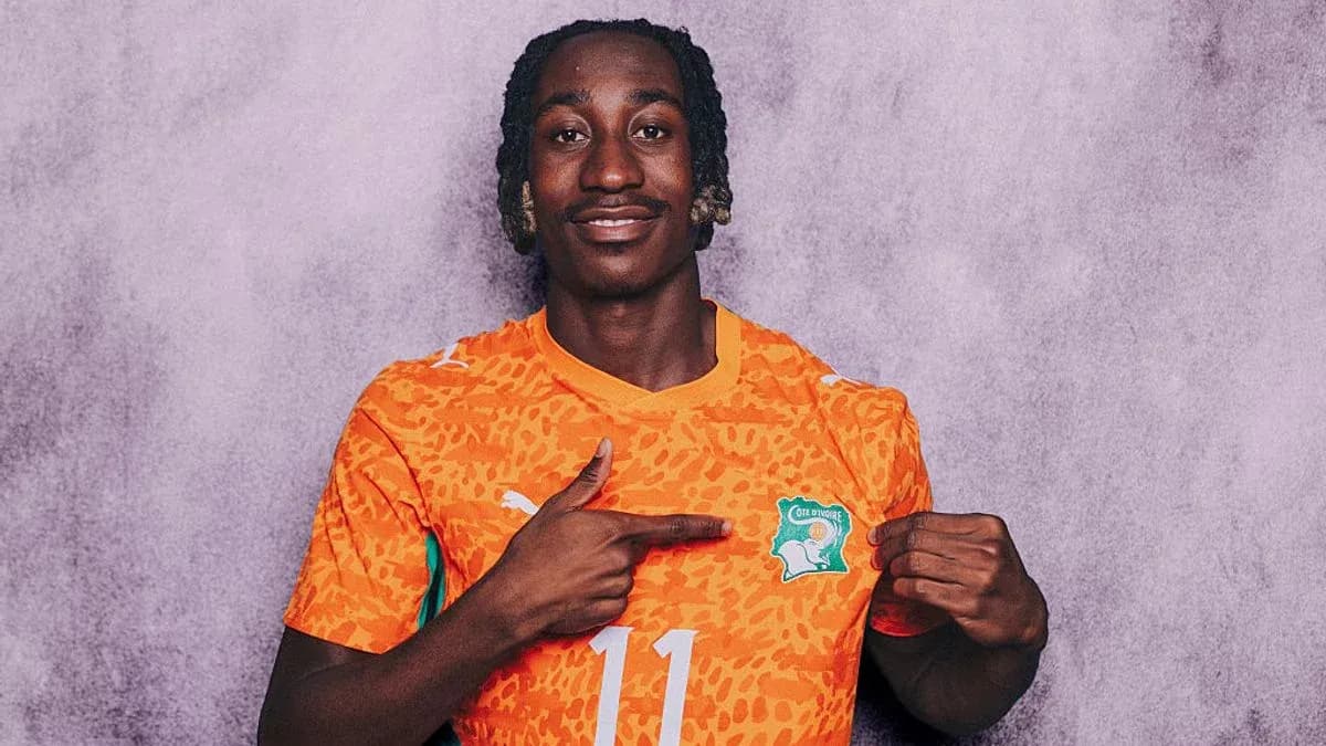 Player in orange jersey pointing at team logo