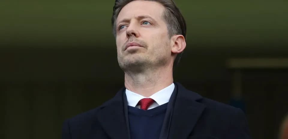 Man in a suit observing from a stadium box