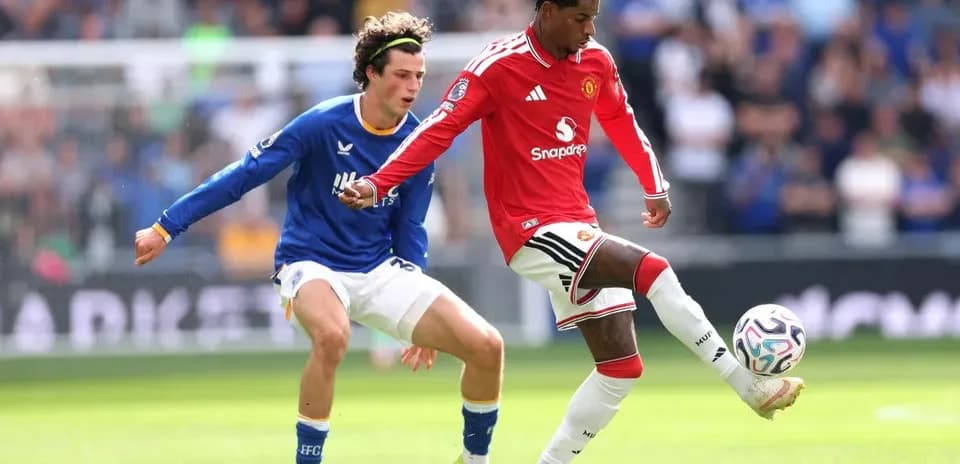 Player in red dribbling past opponent in blue